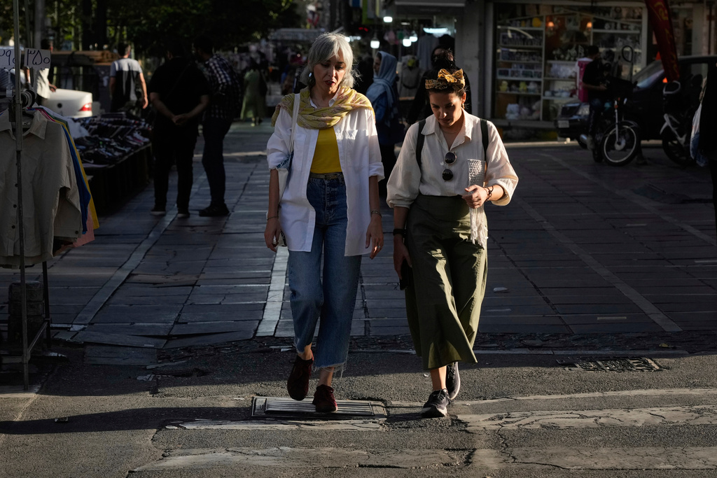 Women cross a street in downtown Tehran, Iran, Thursday, Sept. 18, 2025. (AP Photo/Vahid Salemi)