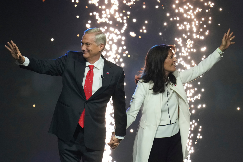 Presidential candidate Jose Antonio Kast, left, of the Republican Party and his wife Maria Pia Adriasola wave to supporters at a campaign rally ahead of general elections, in Santiago, Chile, Tuesday, Nov. 11, 2025. (AP Photo/Esteban Felix)