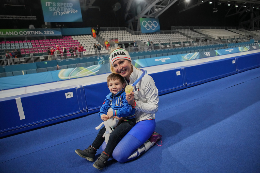 Francesca Lollobrigida of Italy celebrates with her son Tommaso after winning the gold medal in the women's 3,000 meters speedskating race at the 2026 Winter Olympics, in Milan, Italy, Saturday, Feb. 7, 2026.. (AP Photo/Christophe Ena)