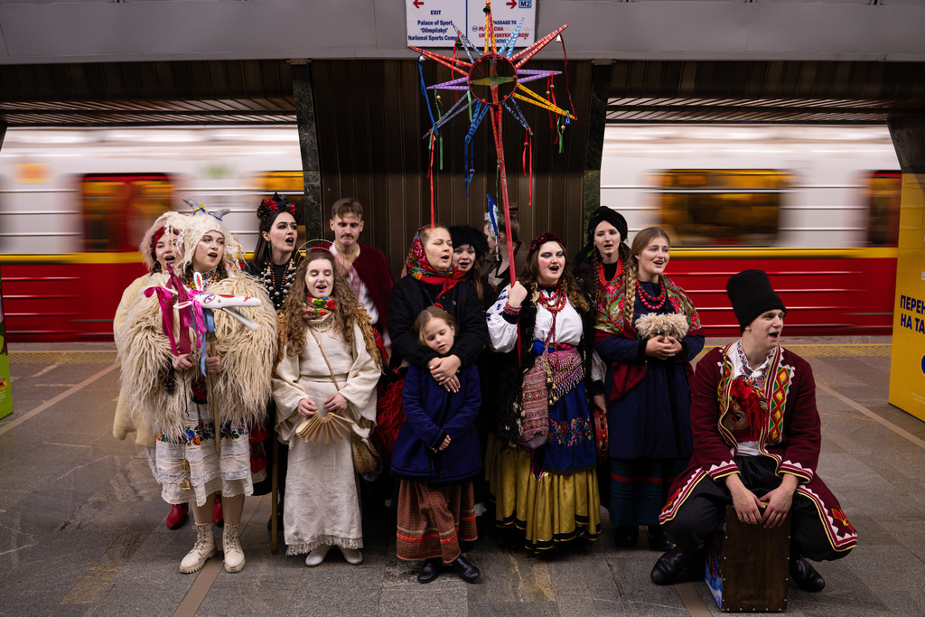 People wearing traditional Ukrainian clothes sign carols on the Christmas Eve at a subway station in central Kyiv, Ukraine, Wednesday, Dec. 24, 2025. (AP Photo/Danylo Antoniuk)