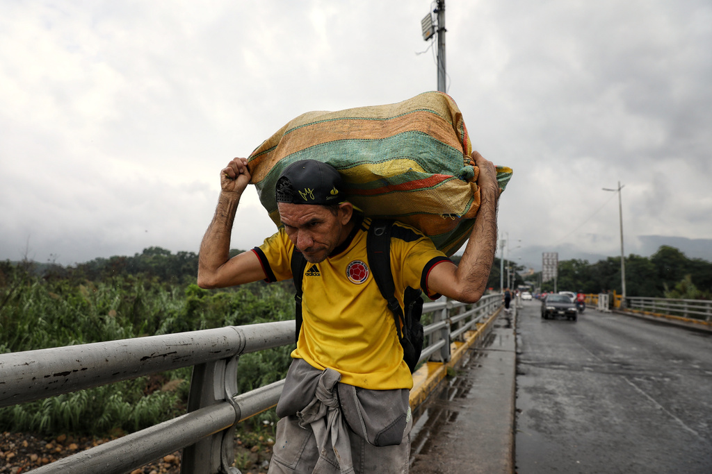 FILE - A man hauls a bag of goods on his shoulders as he crosses the Colombian-Venezuelan border, in Villa del Rosario, Colombia, Jan. 5, 2026, just days after the U.S. capture of Venezuelan President Nicolas Maduro. (AP Photo/Santiago Saldarriaga, File)