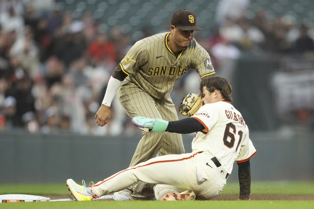 San Francisco Giants' Drew Gilbert (61) is tagged out by San Diego Padres third baseman Manny Machado while trying to reach third base after stealing second base during the third inning of a baseball game in San Francisco, Monday, Aug. 11, 2025. (AP Photo/Jeff Chiu)