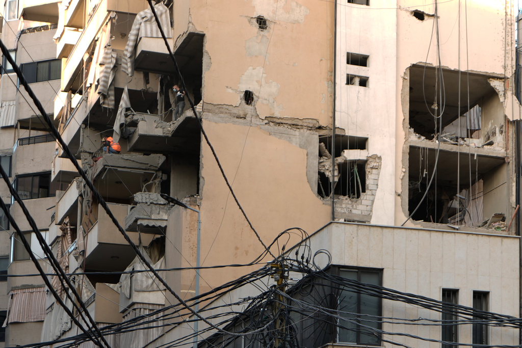 Civil defense workers inspect the damage after an apartment building was hit during an Israeli airstrike on Dahiyeh in the southern suburb of Beirut, Sunday Nov. 23, 2025. (AP Photo/Bilal Hussein)
