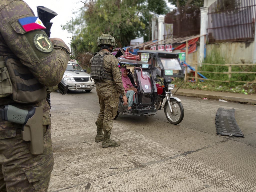 In this photo taken with a smartphone, Army soldiers check the flow of vehical traffic along the highway in Marantao town, Lanao del Sur province, southern Philippines on Sunday Sept 13, 2026. (AP Photo/ Froilan Gallardo)