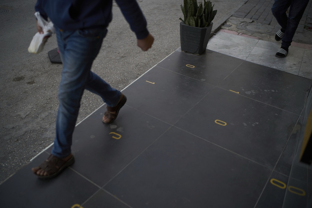 People walk past the spot where 10-year-old Saddam Rajab was shot by an Israeli soldier in the West Bank city of Tulkarem, March 17, 2025. (AP Photo/Leo Correa)