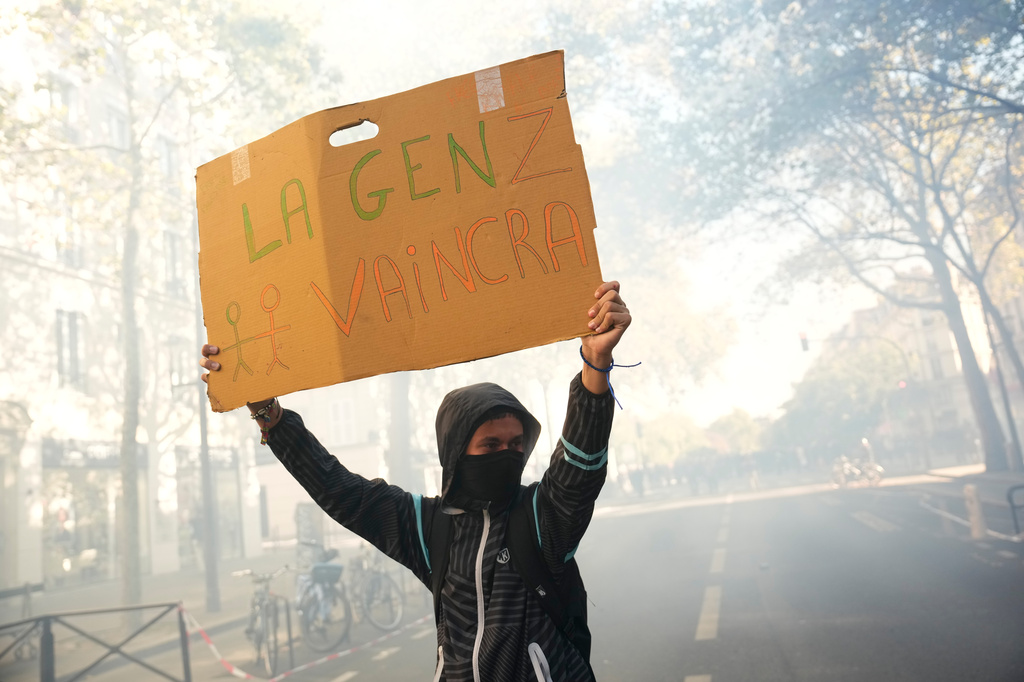 A student holds a board reading 'GenZ will win' during a protest against under-resourced schools, in Paris, Tuesday, Oct. 6, 2026. (AP Photo/Teresa Suarez)