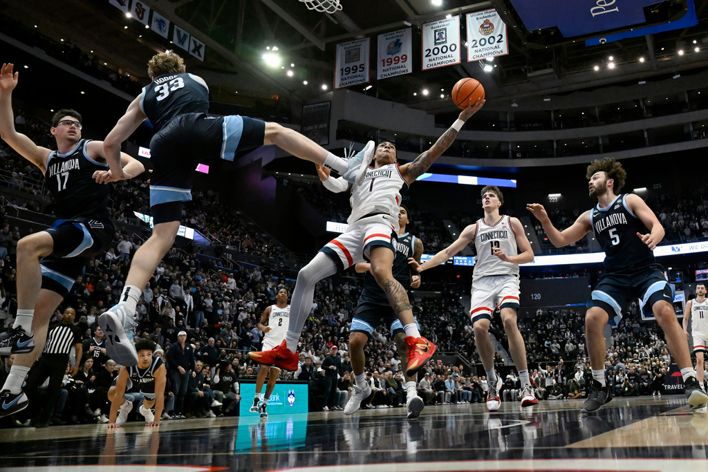UConn guard Solo Ball (1) shoots as Villanova forward Matt Hodge (33) defends in the first half of an NCAA college basketball game, Saturday, Jan. 24, 2026, in Hartford, Conn. (AP Photo/Jessica Hill)