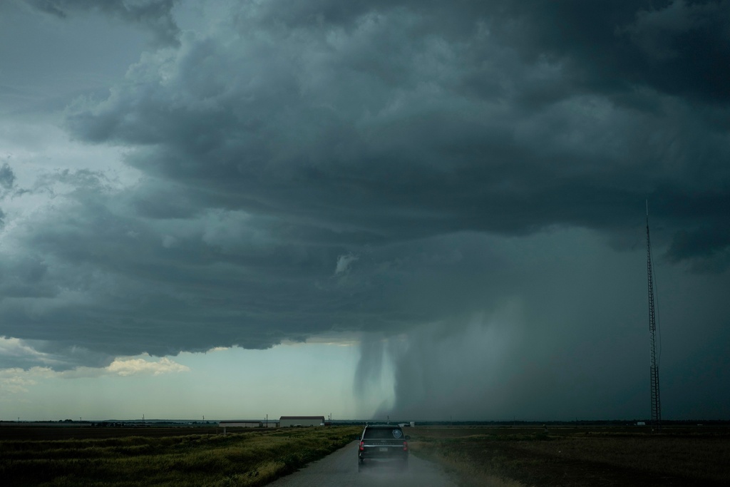 The Project ICECHIP command vehicle drives toward an approaching rainstorm with a rain shaft during an operation, June 3, 2025, near Tipton, Okla. (AP Photo/Carolyn Kaster, File)
