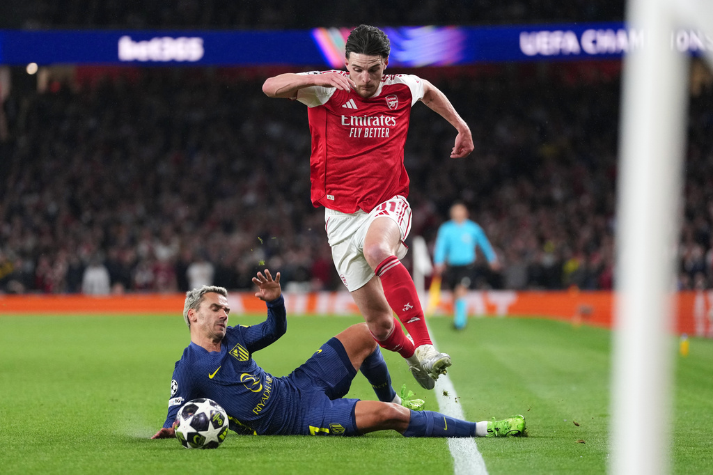 Arsenal's Declan Rice drives the ball past Atletico Madrid's Antoine Griezmann, left, during a Champions League semifinal, second leg, soccer match between Arsenal FC and Atletico Madrid in London, Tuesday, May 5, 2026. (AP Photo/Alastair Grant)