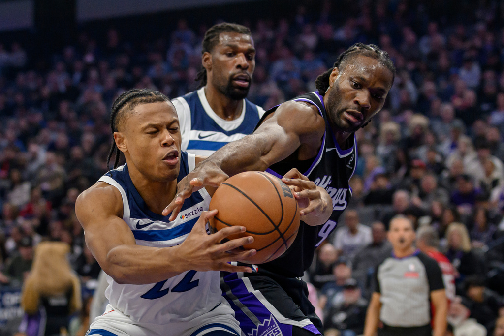 Minnesota Timberwolves guard Jaylen Clark, left, and Sacramento Kings forward Precious Achiuwa (9) battle for a rebound during the first half of an NBA basketball game in Sacramento, Calif., Monday, Nov. 24, 2025. (AP Photo/Randall Benton)