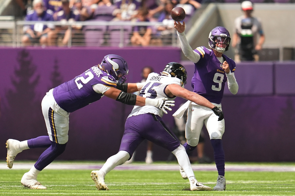 Minnesota Vikings quarterback J.J. McCarthy (9) throws against pressure by Baltimore Ravens linebacker Ethan Burke (45) during the first half of an NFL preseason football game, Saturday, Aug. 22, 2026, in Minneapolis. (AP Photo/Abbie Parr)