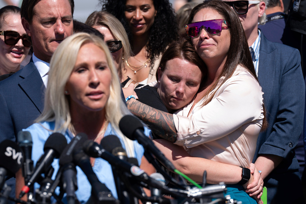FILE - Jena-Lisa Jones, center, hugs Haley Robson, right, as Rep. Marjorie Taylor Greene, R-Ga., left, speaks during a news conference at the U.S. Capitol, Sept. 3, 2025, in Washington. (AP Photo/Jose Luis Magana, File)