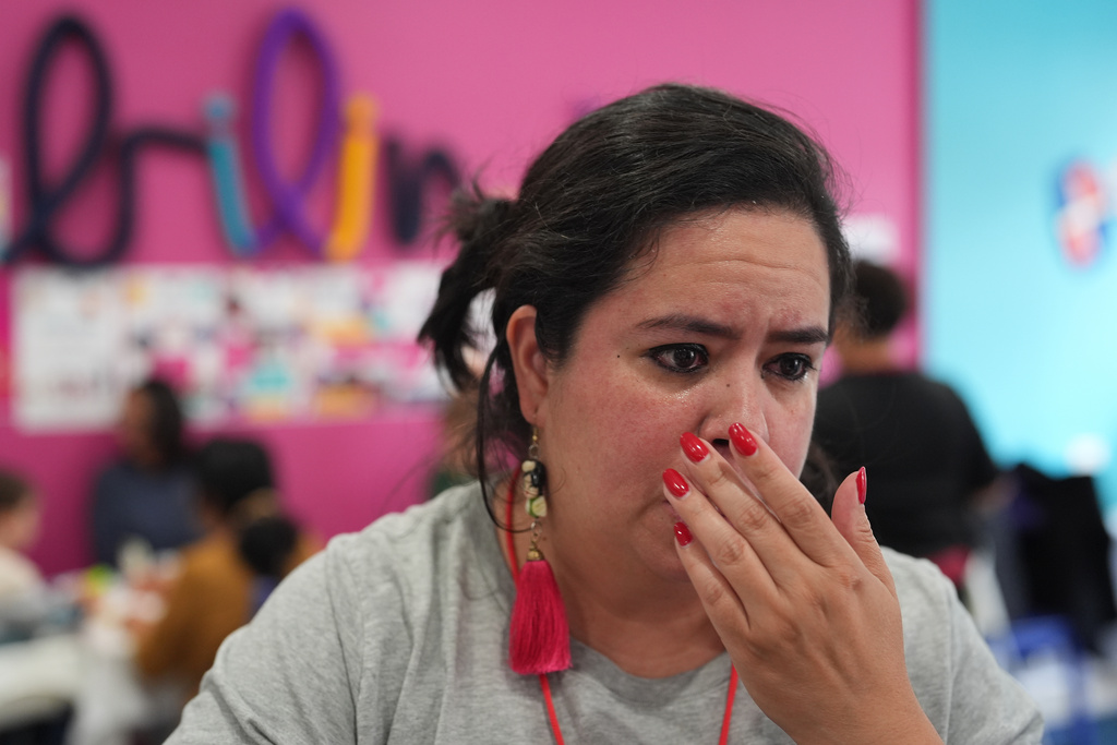 Vanessa Aguirre-Avalos, owner of Luna y Cielo Play Cafe, wipes tears after reading a letter from parent Molly Kucich to her congressperson about the day federal immigration agents deployed tear gas in the street outside the cafe where children learn Spanish as they play in Chicago's Logan Square neighborhood, Wednesday, Oct. 15, 2025. (AP Photo/Rebecca Blackwell)