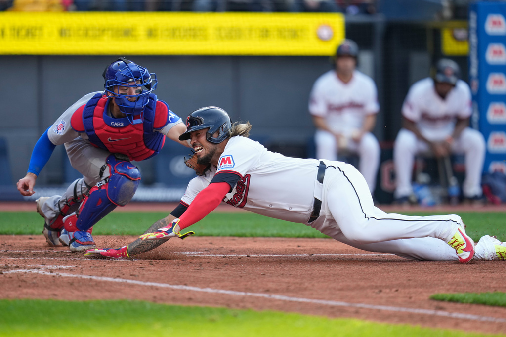 Cleveland Guardians shortstop Gabriel Arias, right, is tagged out at home by Chicago Cubs catcher Carson Kelly, left, in the fifth inning of a baseball game in Cleveland, Friday, April 3, 2026. (AP Photo/Sue Ogrocki)