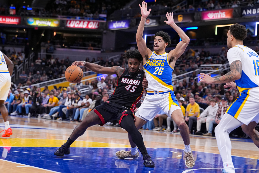 Miami Heat guard Davion Mitchell (45) is stopped by Indiana Pacers guard Ben Sheppard (26) during the second half of an NBA basketball game in Indianapolis, Sunday, March 29, 2026. (AP Photo/Michael Conroy)
