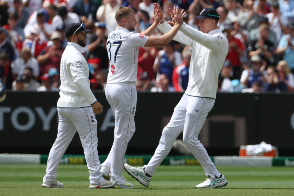England's Gus Atkinson, center, celebrates with teammates after bowling Australia's Travis Head during their Ashes cricket test match in Melbourne, Friday, Dec. 26, 2025. (AP Photo/Hamish Blair)