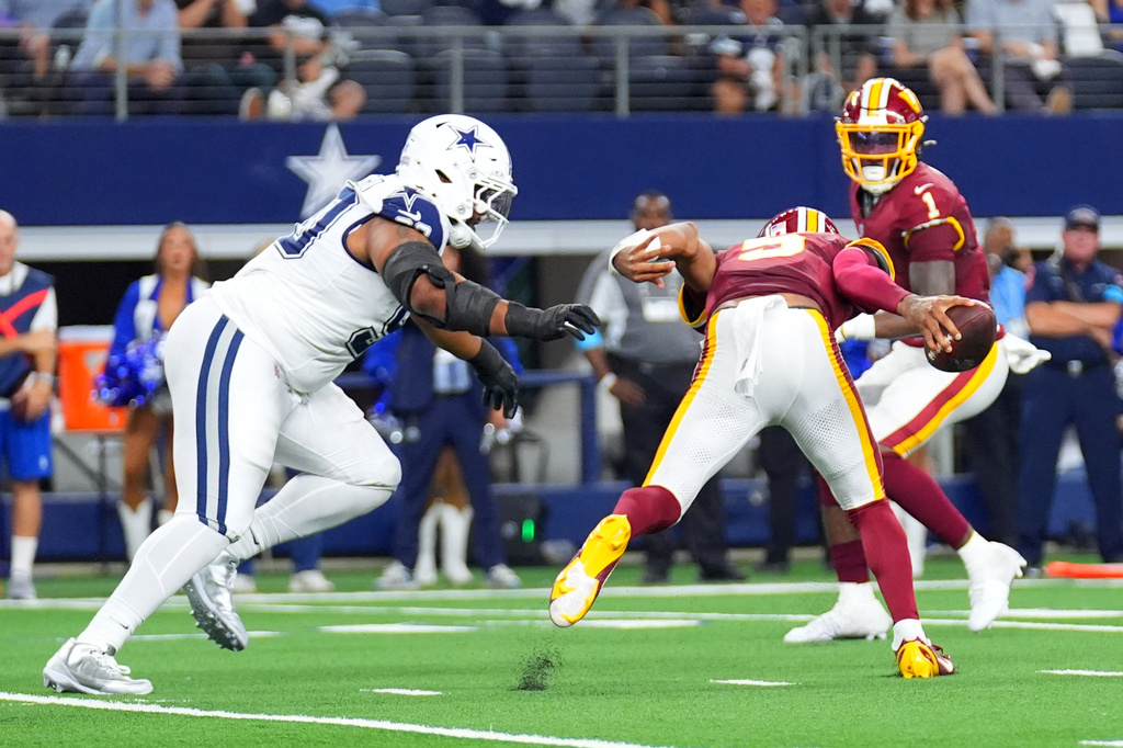 Washington Commanders quarterback Jayden Daniels (5) reacts after an apparent injury in the first half against the Dallas Cowboys during an NFL football game in Arlington, Texas, Sunday, Sept. 20, 2026. (AP Photo/Julio Cortez)