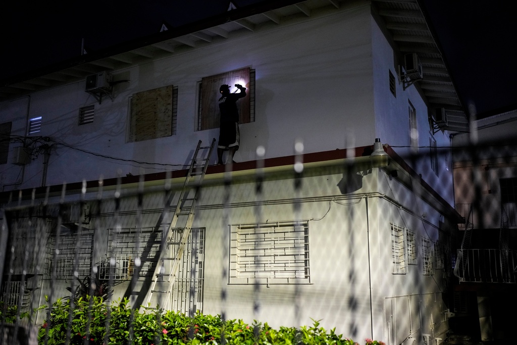 A man boards up a hotel's windows in preparation of Hurricane Melissa's expected arrival in Kingston, Jamaica, Saturday, Oct. 25, 2025. (AP Photo/Matias Delacroix)