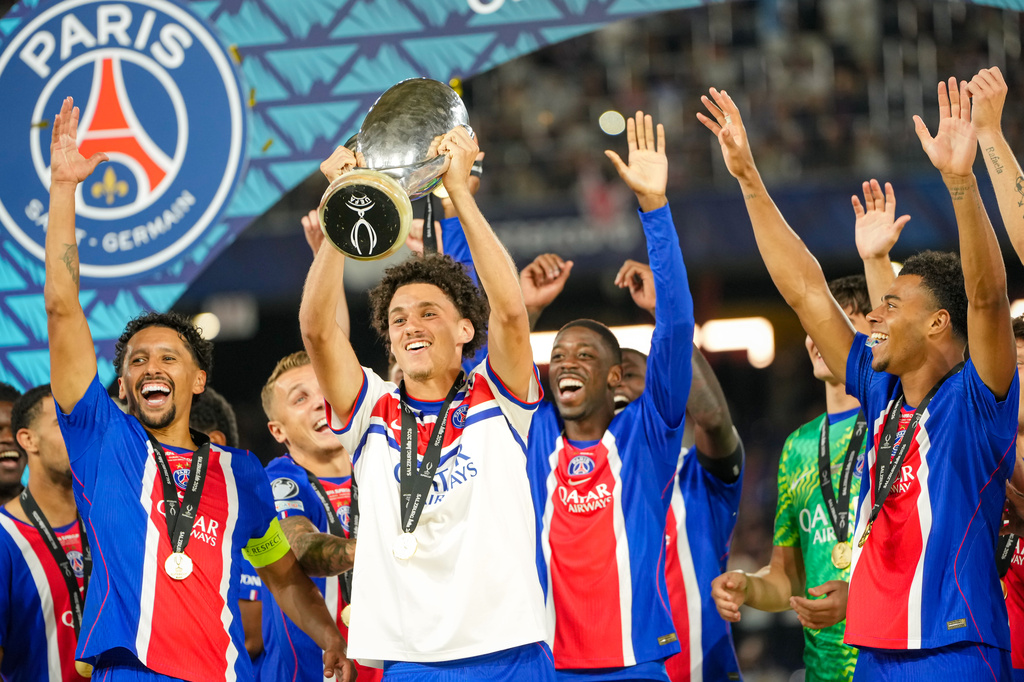 PSG's Maghnes Akliouche lifts the trophy during celebrations at the end of the UEFA Super Cup soccer match between Paris Saint-Germain and Aston Villa in Salzburg, Austria, Wednesday, Aug.12, 2026. (AP Photo/Darko Bandic)