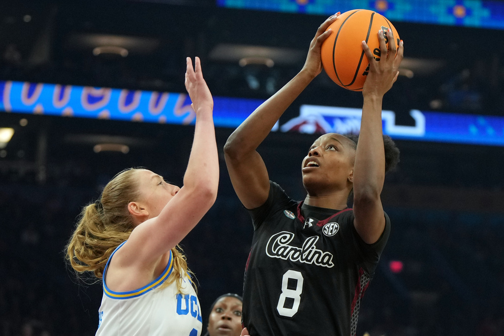 South Carolina forward Joyce Edwards (8) shoots over UCLA guard Gianna Kneepkens (8) during the first half of the women's National Championship Final Four NCAA college basketball tournament game, Sunday, April 5, 2026, in Phoenix. (AP Photo/Rick Scuteri)