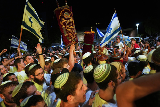 Jewish revelers dance and hold up the Torah as they celebrate the holiday of Simchat Torah at the plaza known as hostages square in Tel Aviv, Israel, Tuesday, Oct. 14, 2025. (AP Photo/Francisco Seco) Jewish revelers dance and hold up the Torah as they celebrate the holiday of Simchat Torah at the plaza known as hostages square in Tel Aviv, Israel, Tuesday, Oct. 14, 2025. (AP Photo/Francisco Seco)