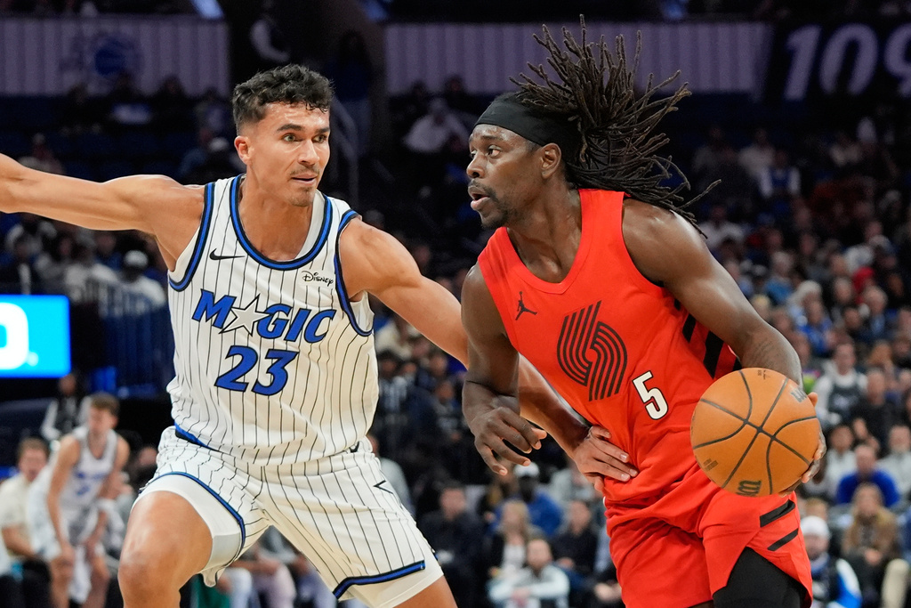 Portland Trail Blazers guard Jrue Holiday (5) drives past Orlando Magic forward Tristan da Silva (23) during the first half of an NBA basketball game, Monday, Nov. 10, 2025, in Orlando, Fla. (AP Photo/John Raoux)