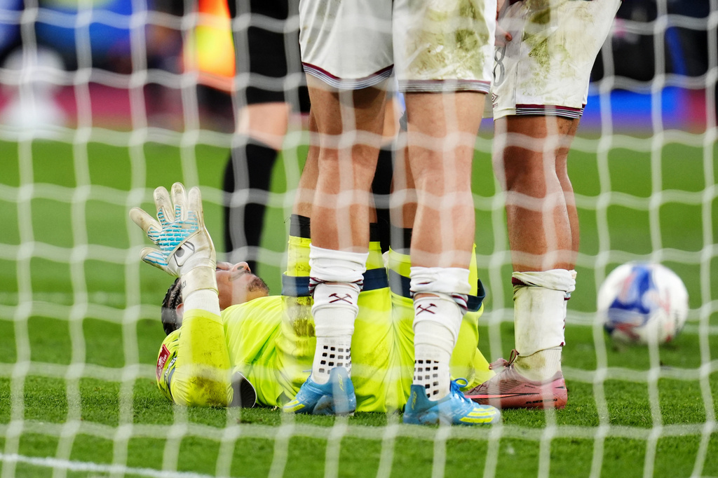 West Ham United goalkeeper Alphonse Areola goes down injured before being replaced by substitute goalkeeper Finlay Herrick in extra-time during the English FA Cup quarterfinal soccer match between West Ham United and Leeds United, in London, Sunday April 5, 2026. (John Walton/PA via AP)