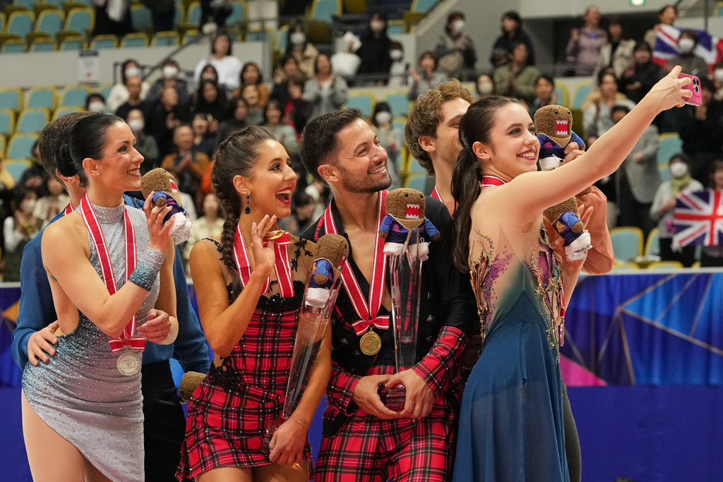 Gold medalists Lilah Fear and Lewis Gibson of Britain, center, silver medalists Charlene Guignard and Marco Fabbri of Italy, left, and bronze medalists Caroline Green and Michael Parsons of the U.S., pose for a selfie after the award ceremony for the Ice Dance Free Dance at ISU Grand Prix of Figure Skating - NHK Trophy in Kadoma, east of Osaka, western Japan, Saturday, Nov. 8, 2025. (AP Photo/Hiro Komae)