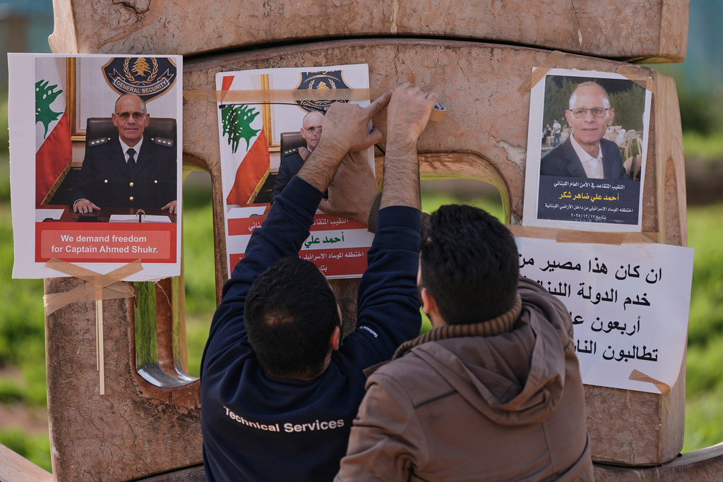 Family members of retired Lebanese officer Ahmed Shukr, hang posters of him during a gathering outside the headquarters of the U.N. Economic and Social Commission for Western Asia, ESCWA, in Beirut, Lebanon, Friday, Feb. 13, 2026. (AP Photo/Bilal Hussein)