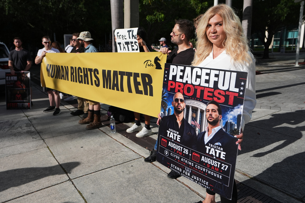 Azeneth Gregoira, a supporter of Andrew and Tristan Tate, holds a sign supporting the brothers outside the C. Clyde Atkins U.S. Courthouse before a bond hearing as the Tates fight extradition to the United Kingdom on rape and sex trafficking charges, Thursday, Aug. 27, 2026, in Miami. (AP Photo/Lynne Sladky)