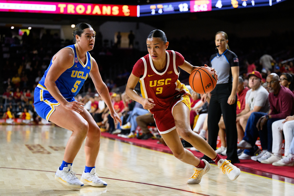 Southern California guard Jazzy Davidson (9) drives the ball while under pressure from UCLA guard Charlisse Leger-Walker (5) during the first half of an NCAA college basketball game Sunday, March 1, 2026, in Los Angeles. (AP Photo/William Liang)