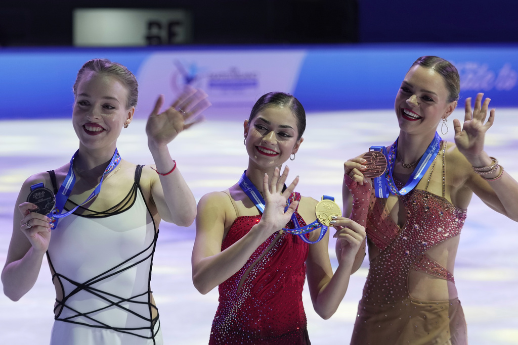 Gold medalist Adeliia Petrosian of Russia, competing as a neutral athlete, centre, poses with silver medalist Anastasiia Gubanova of Georgia, left, and bronze medalist Loena Hendrickx of Belgian, right, after competing in Women free skating at the ISU Skate to Milano figure skating qualifier 2025, in Beijing, China, Saturday, Sept. 20, 2025. (AP Photo/Mahesh Kumar A.)