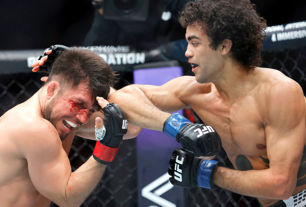 Henry Cejudo, left, is hit with an elbow by Payton Talbott, right, in a bantamweight mixed martial arts bout during UFC 323, Saturday, Dec. 6, 2025, in Las Vegas. (Steve Marcus/Las Vegas Sun via AP)