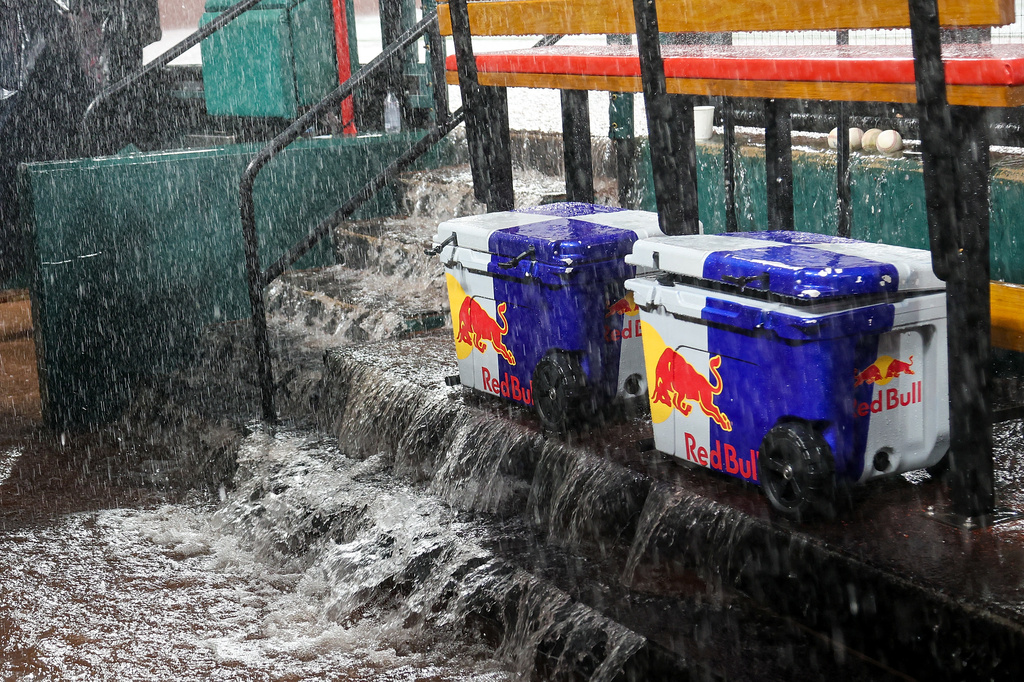Water flows down the steps into the dugout during a rain delay in the fourth inning of a baseball game between the St. Louis Cardinals and the Atlanta Braves Friday, July 10, 2026, in St. Louis. (AP Photo/Scott Kane)