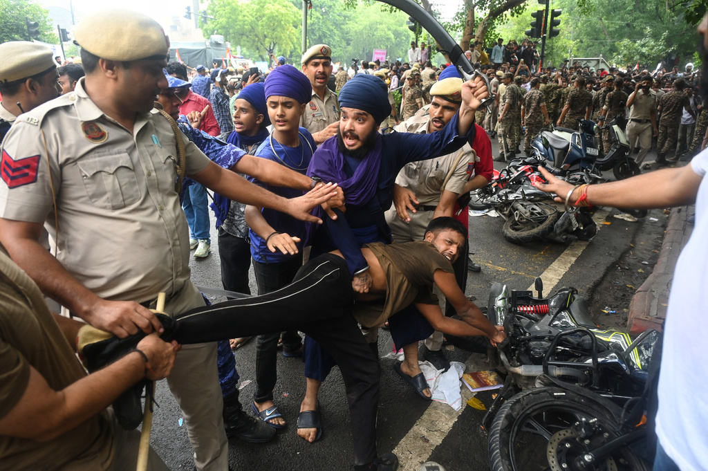 Supporters of the Cockroach Janta Party scuffle with police as they attempt to march toward India's Parliament, demanding the resignation of the education minister, in New Delhi, Monday, July 20, 2026. (AP Photo/Vipin)
