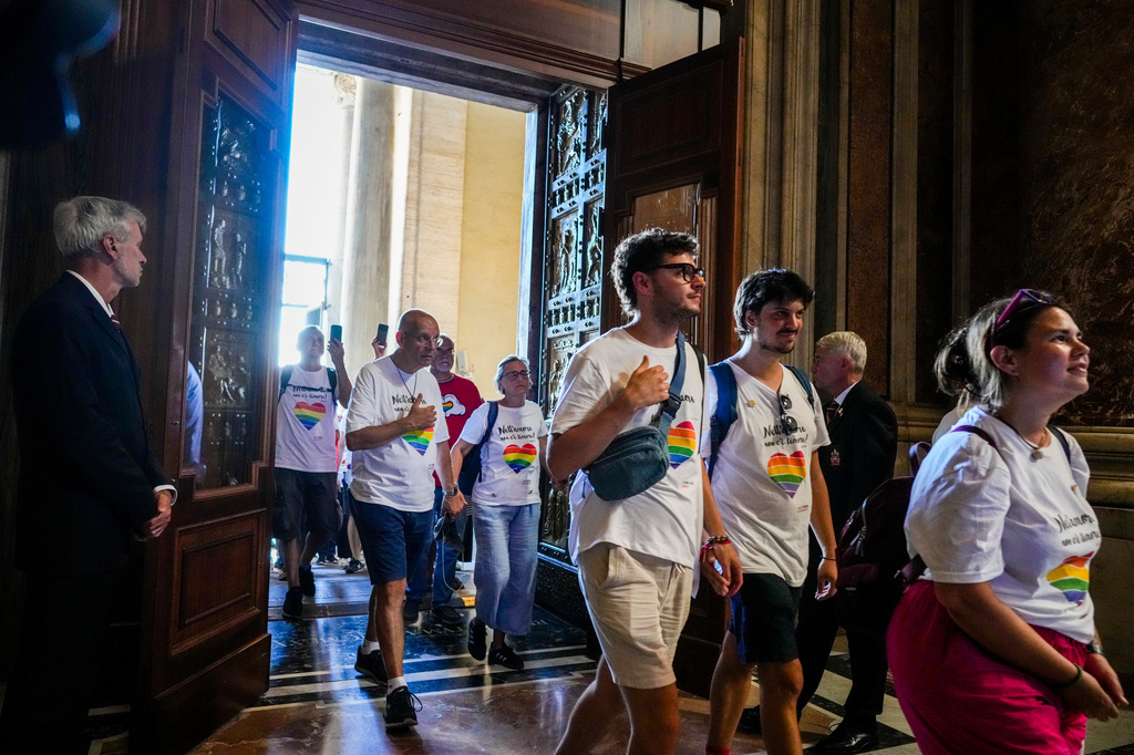 FILE - Members of the LGBTQ+ Catholics and their families who joined a Holy Year pilgrimage to Rome walk through the Holy Door of St. Peter's Basilica at the Vatican, Saturday, Sept. 6, 2025. (AP Photo/Andrew Medichini, File)