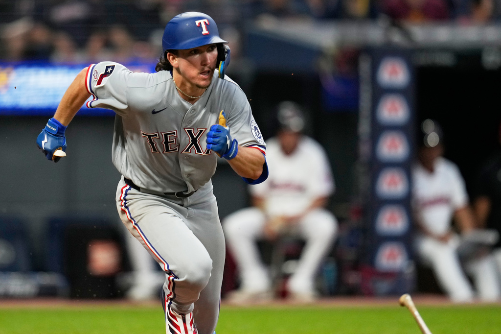 Texas Rangers' Cameron Cauley drops his bat and runs towards first base with a triple, his first major league hit, in the seventh inning of a baseball game against the Cleveland Guardians in Cleveland, Monday, June 29, 2026. (AP Photo/Sue Ogrocki)