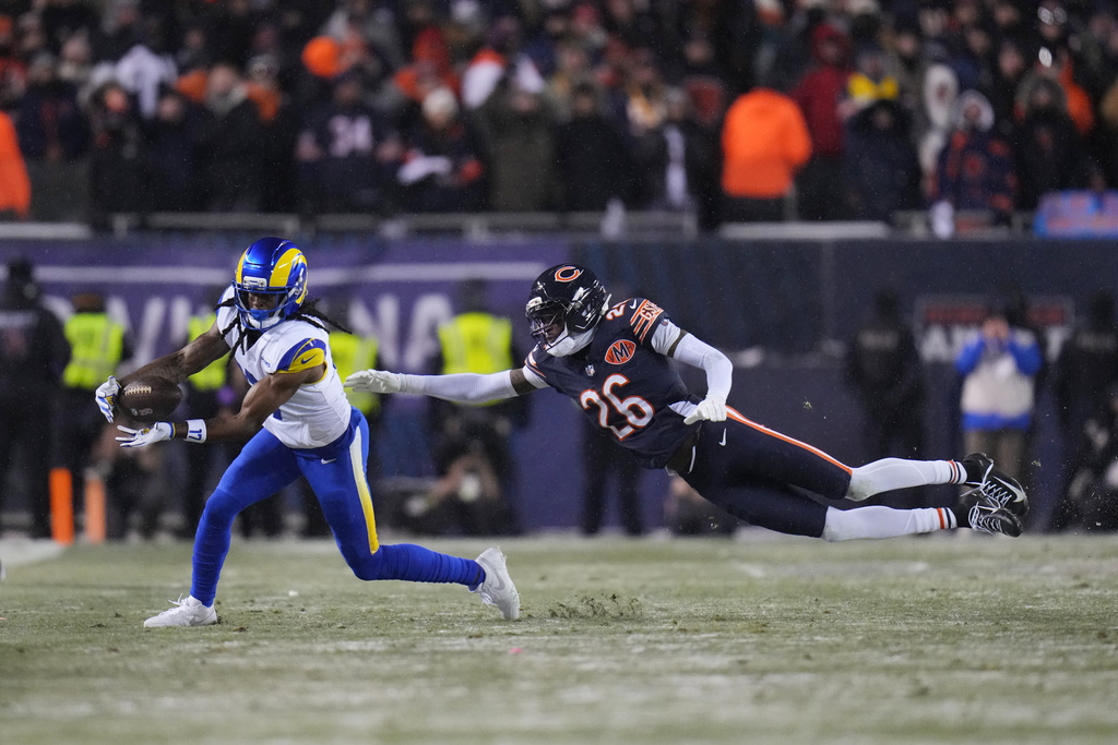 Los Angeles Rams wide receiver Davante Adams, left, makes a first down catch against Chicago Bears cornerback Nahshon Wright during overtime of an NFL football divisional playoff game Sunday, Jan. 18, 2026, in Chicago. (AP Photo/Jeff Roberson)