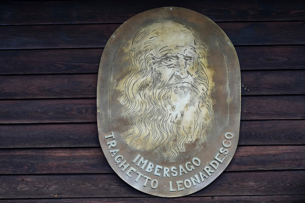 An effigy of Leonardo da Vinci hangs on the dock of the “Da Vinci Ferry,” a hand-operated of a type sketched by Leonardo da Vinci in 1513, on the Adda River between the provinces of Lecco and Bergamo, in Imbersago, Italy, Thursday, June 4, 2026. (AP Photo/Luca Bruno)