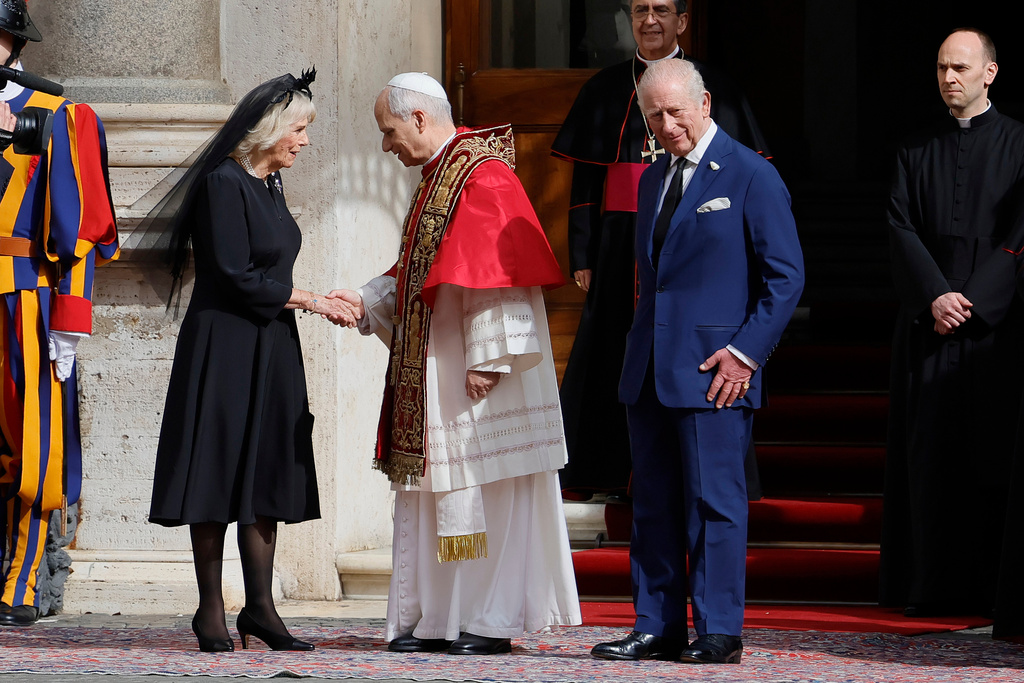 Pope Leo XIV, center, shakes hands with Britain's Queen Camilla as King Charles III looks on, in the St. Damasus Courtyard at the Vatican after a state visit and pray with him in the Sistine Chapel, Thursday, Oct. 23, 2025. (Cecilia Fabiano/LaPresse via AP)