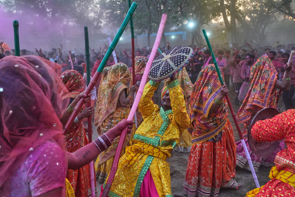 Women devotees symbolically beat men with wooden sticks to mark Lathmar Holi during Holi festival celebrations at the Shri Krishna Janmabhoomi Temple complex in Mathura, India, on Feb. 27, 2026. (AP Photo/Manish Swarup)