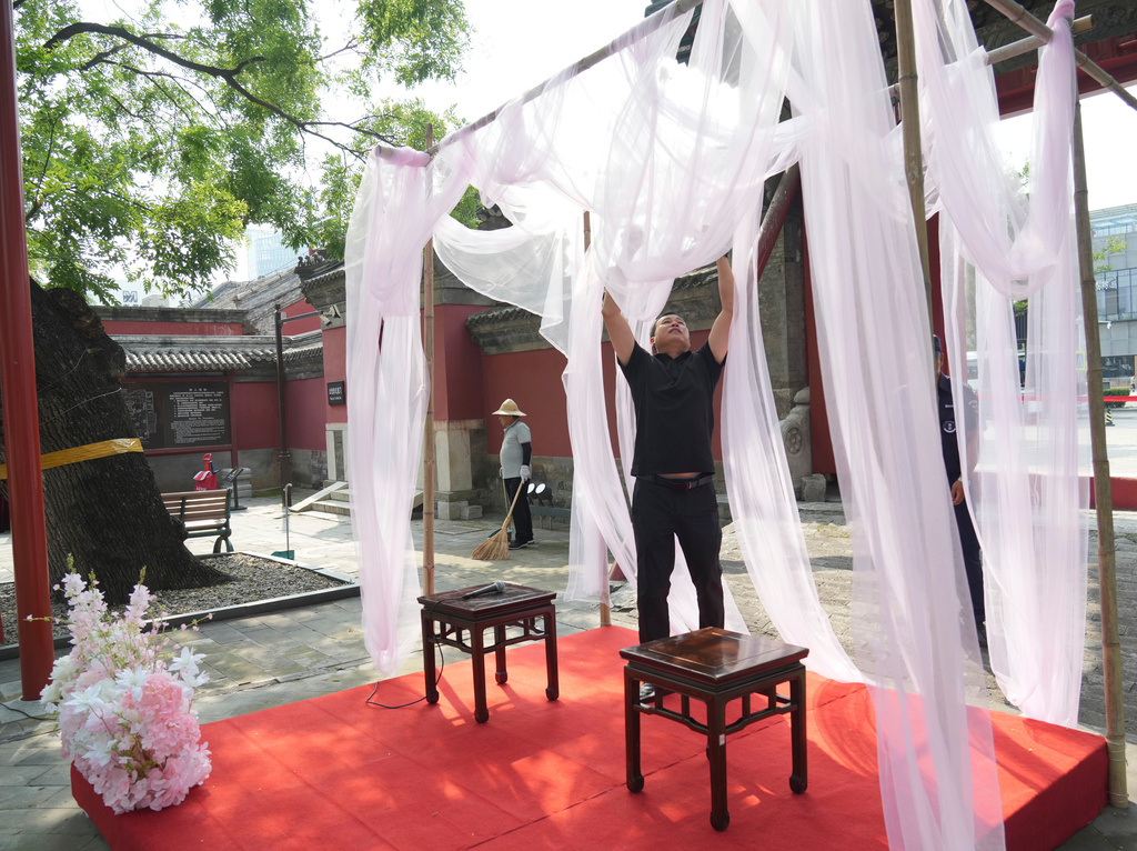 A worker decorates ahead of a festival to celebrate Qixi at the Beijing Folk Custom Museum in Beijing, Wednesday, Aug. 19, 2026. (AP Photo/Achmad Ibrahim)