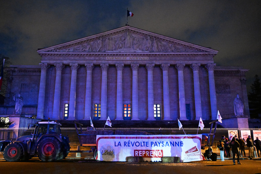Farmers protest by the National Assembly as they protest against the Mercosur EU trade deal with South America they fear threatens their livelihoods, Tuesday, Jan. 13, 2026 in Paris. Banner reads: the peasant revolt resumes. (AP Photo/Emma Da Silva)