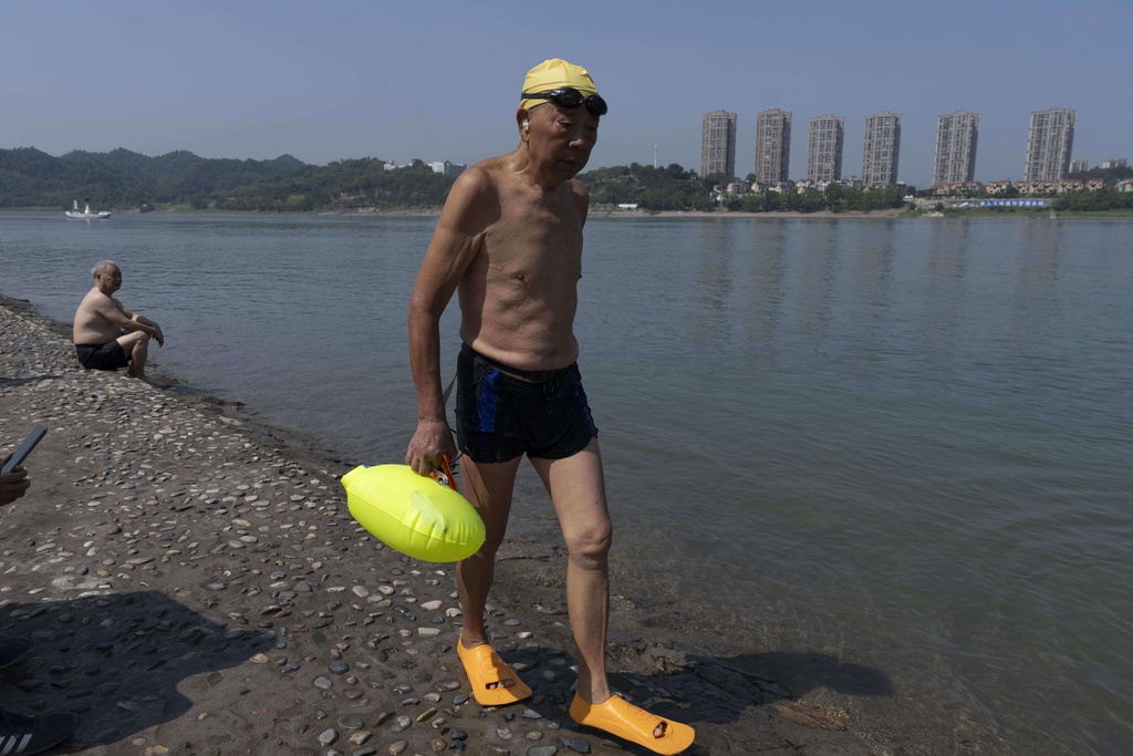 An elderly man walks along the banks of the Yangtze River after swimming near Yichang in central China's Hubei province on June 16, 2025. (AP Photo/Ng Han Guan)