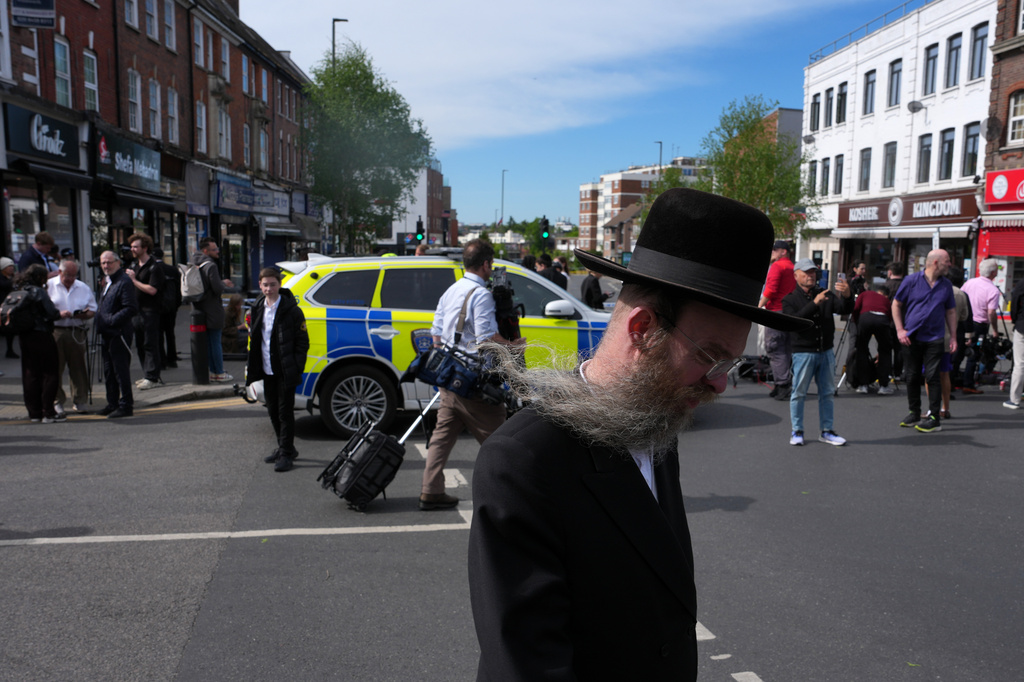 A man walks past a blocked road after two people were stabbed in Golders Green neighbourhood, that has a large Jewish community, in London, Wednesday, April 29, 2026.(AP Photo/Kin Cheung)