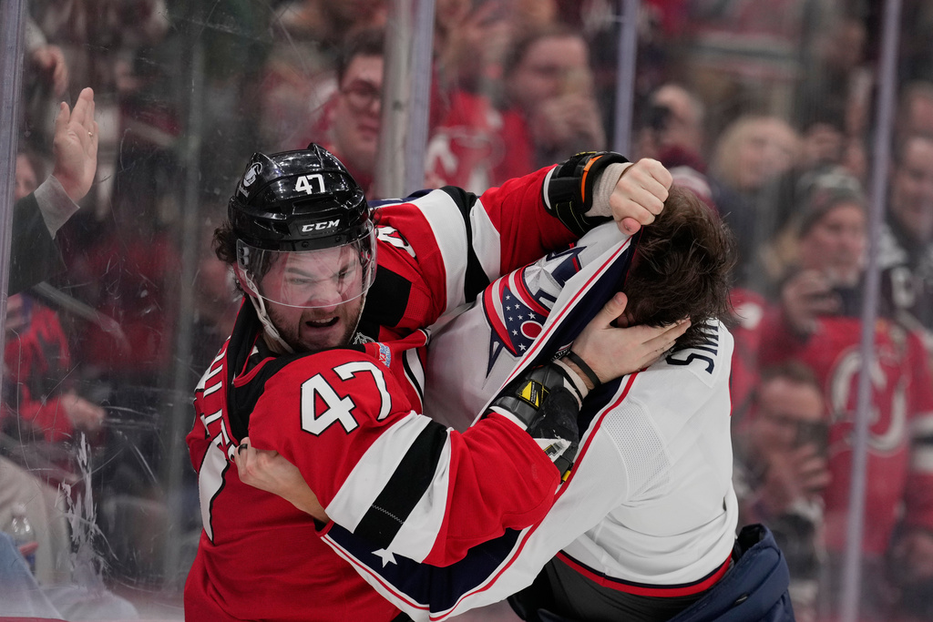 New Jersey Devils' Paul Cotter, left, fights with Columbus Blue Jackets' Brendan Smith during the second period of an NHL hockey game in Newark, N.J., Monday, Dec. 1, 2025. (AP Photo/Seth Wenig)