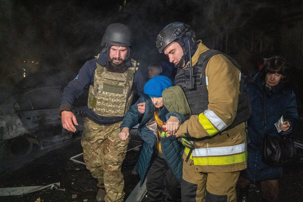 Rescuers evacuate an elderly woman after a residential building was hit following Russia's missile attack in Kharkiv, Ukraine Wednesday, Nov. 19, 2025. (AP Photo/Andrii Marienko)