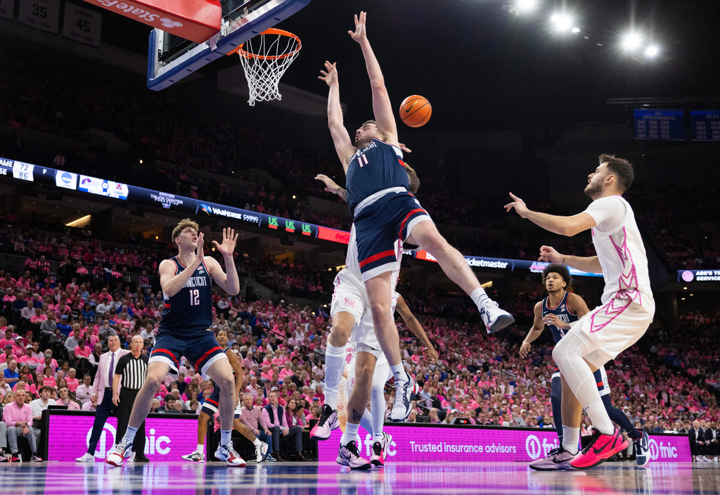 UConn's Alex Karaban (11) shoots against Creighton's Owen Freeman, obscured, during the first half of an NCAA college basketball game Saturday, Jan. 31, 2026, in Omaha, Neb. (AP Photo/Rebecca S. Gratz)