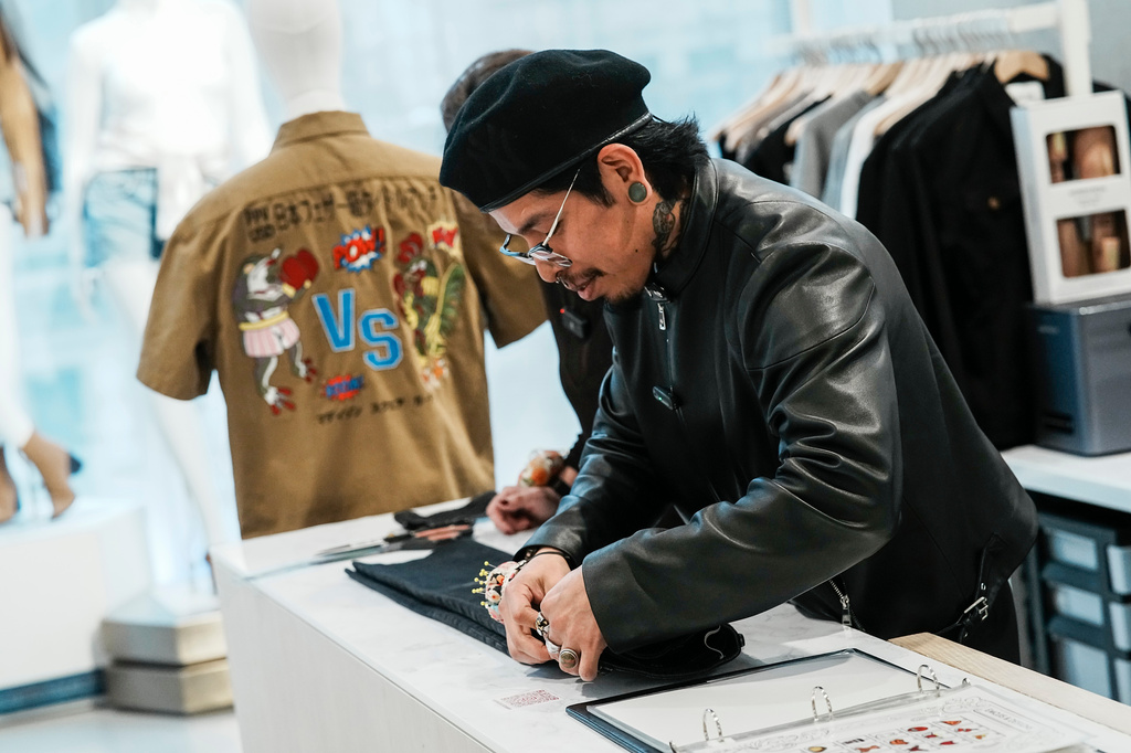 Tailor Marco Lema, 35, of Ecuador, works on a denim alteration at Nordstrom headquarters in New York, Monday, March 23, 2026. (AP Photo/Eduardo Munoz Alvarez)