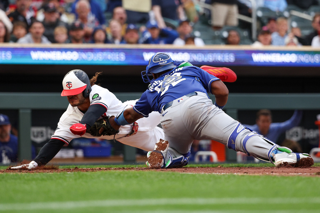 Los Angeles Dodgers catcher Chuckie Robinson tags out Minnesota Twins' Austin Martin at home plate during the third inning of a baseball game, Tuesday, June 23, 2026, in Minneapolis. (AP Photo/Matt Krohn)